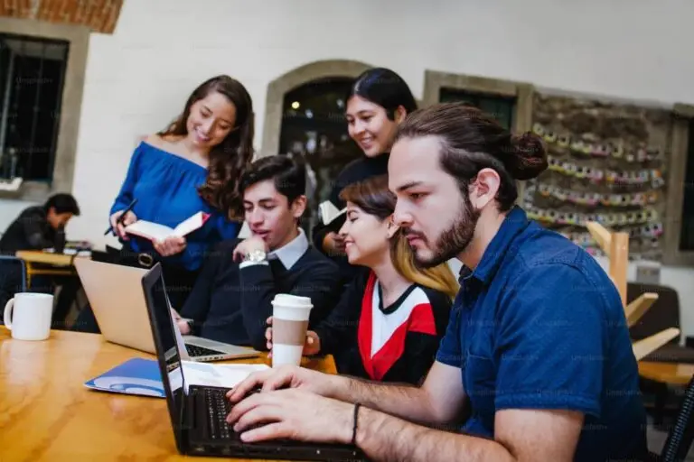 indian and international students working together on computers in a bright and modern university computer lab